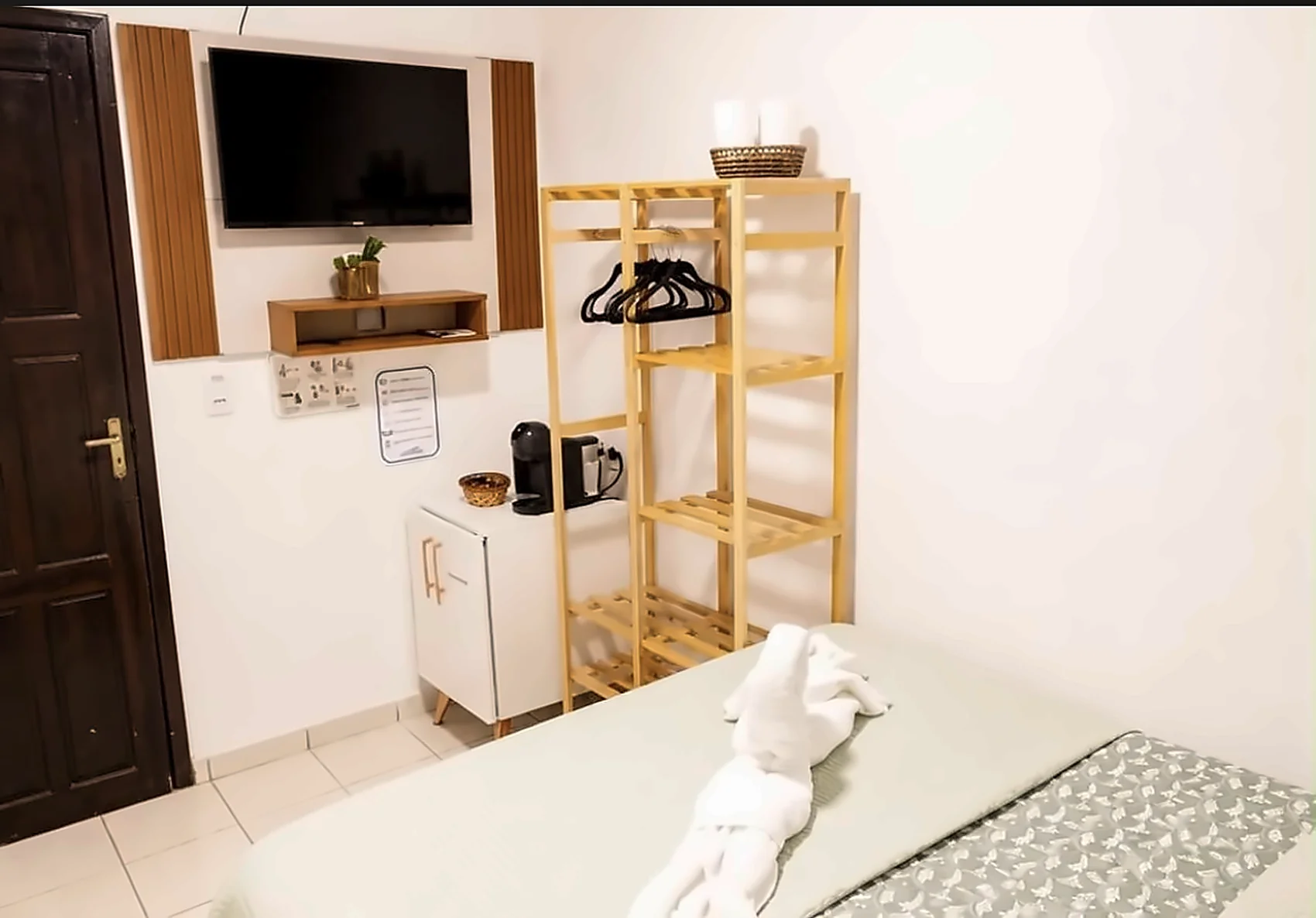 Visão geral do Quarto Standard com cama, frigobar e televisão